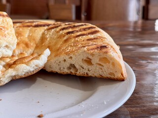 A Deliciously Freshly Baked Flatbread Featuring EyeCatching Grilled Patterns on Top. This scrumptious, golden brown flatbread features distinct and unique grill marks, making it ideal for any meal