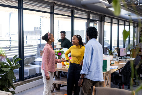 Diverse colleagues collaborating and discussing ideas in modern office with large windows