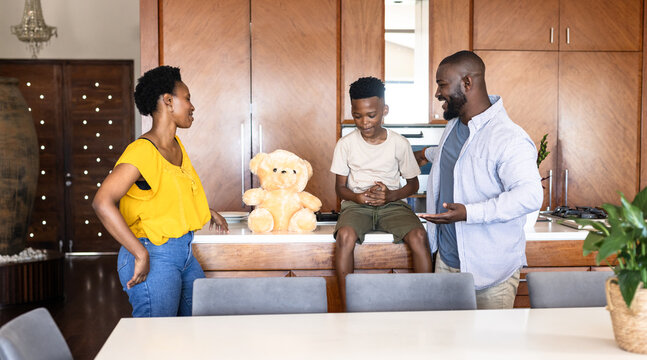 Family enjoying quality time together in modern kitchen with teddy bear, at home