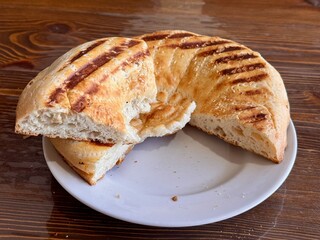 A Deliciously Freshly Baked Flatbread Featuring EyeCatching Grilled Patterns on Top. This scrumptious, golden brown flatbread features distinct and unique grill marks, making it ideal for any meal