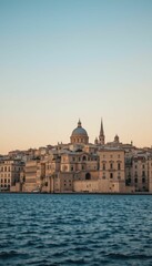Fototapeta premium Scenic View of Historic City Along Serene Water at Sunset