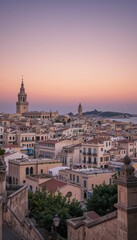 Obraz premium Beautiful Sunset Over Historic Cityscape with Tower and Rooftops