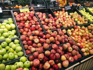 Large assortment of red and green apples on the counter on the shelf in Moscow supermarket. Russia, Moscow 02.02.2025.