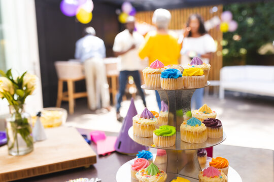 At party, Cupcakes on display at happy family gathering, people celebrating in background