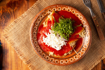 Entomatadas. Also known as Enjitomatadas, a typical dish of Mexican cuisine prepared with corn tortilla, tomato sauce and stuffed with shredded chicken meat. Classic homemade recipe.