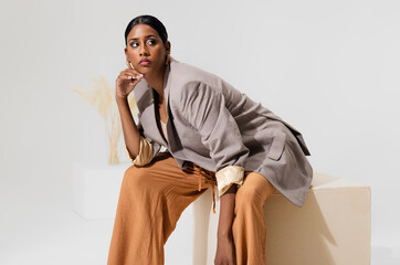 Stylish woman in elegant blazer posing confidently in modern fashion studio