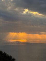 The sun shines brightly through clouds over the oceans surface