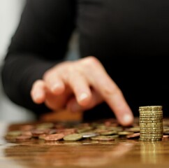 saving coins with money to pay bills having the intention of calculating raising more money to be...