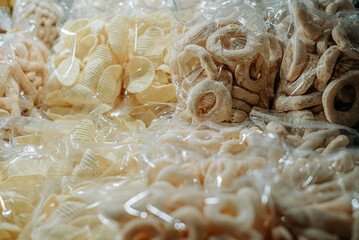 Transparent bags filled with chips and snacks on a table, showcasing various crisp and savory treats