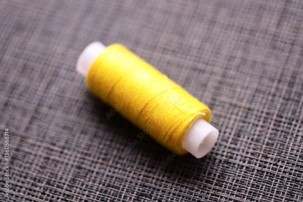 Poster A spool of thread sitting on a table, ready for use in various crafts and projects.