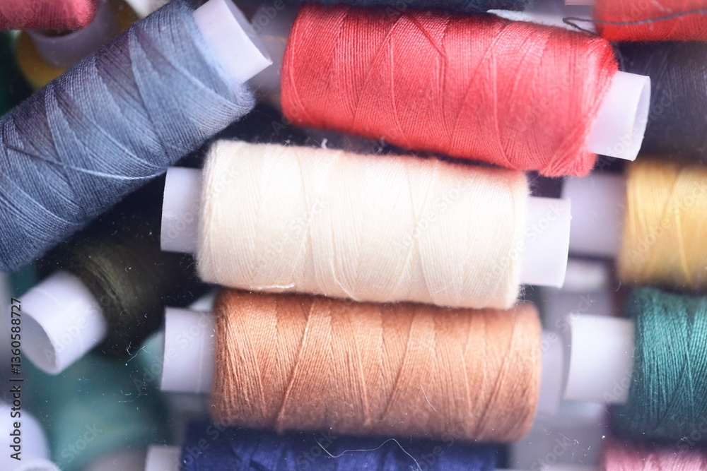 Poster close-up shot of multiple spools of thread, ideal for crafting or sewing projects.