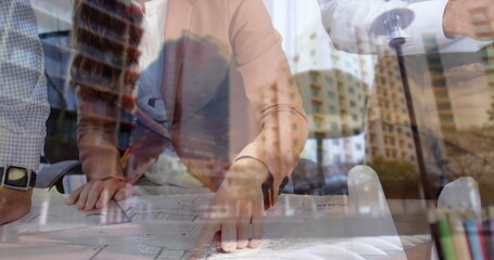 Architects collaborating on blueprints in modern office, planning urban development