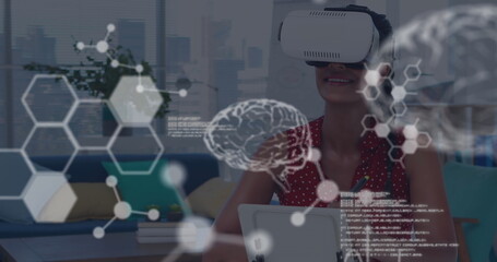 Woman using VR headset exploring virtual brain simulation in modern office