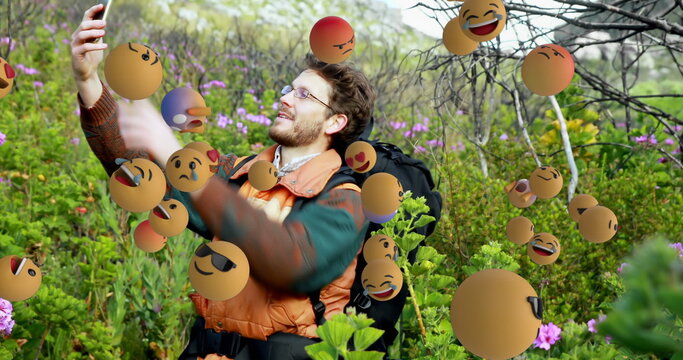 Hiker in nature taking selfie surrounded by floating emojis, enjoying moment - Powered by Adobe