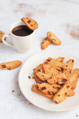 Italian raisin almond biscotti and glass of milk on light background.