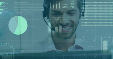 Smiling man with headset analyzing digital data on computer screen at office