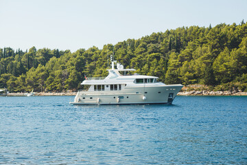 A luxurious yacht sails through scenic ocean waters, offering an unforgettable experience