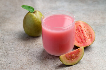 Refreshing guava juice and fresh fruits on grey table, closeup