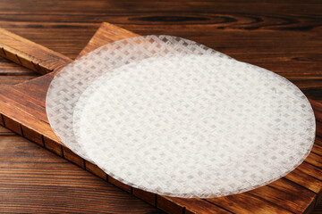 Edible rice paper sheets on wooden table, closeup