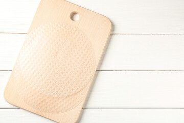 Edible rice paper sheets on white wooden table, top view. Space for text