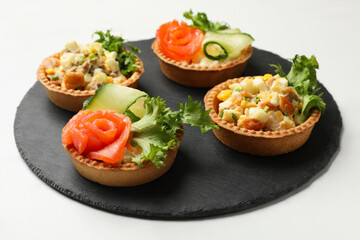Tartlets with delicious fillings on white table, closeup