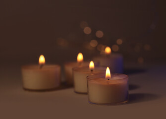 Soft focus. blur Burning candles in dark. Evening, night Light and shadow brown background. Minimalist still life.