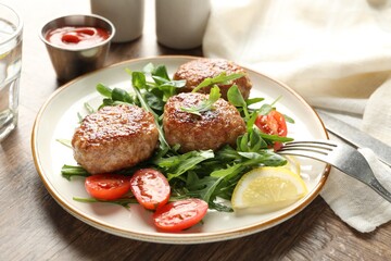 Delicious patties with greens, tomatoes, ketchup and drink on wooden table, closeup