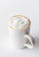 Fototapeta premium Close-up of a pristine white cup filled with creamy cappuccino froth against a pure white backdrop, beverage photography, background, creamy texture