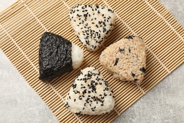 Tasty onigiri (Japanese rice balls) on grey table, top view