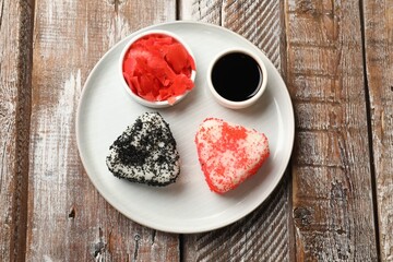 Tasty tobiko onigiri (Japanese rice balls) served on wooden table, top view
