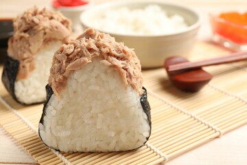 Tasty onigiri (Japanese rice balls) with tuna served on table, closeup