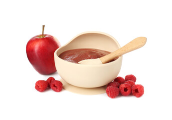 Baby food. Tasty puree in bowl, spoon, apple and raspberries isolated on white
