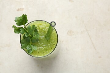 Healthy parsley smoothie in glass on light textured table, top view. Space for text