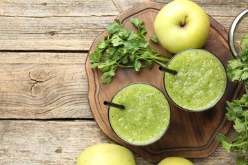 Healthy parsley smoothie in glasses, leaves and apples on wooden table, flat lay. Space for text