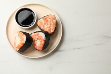 Tasty onigiri (Japanese rice balls) with shrimps and soy sauce on white marble table, top view. Space for text