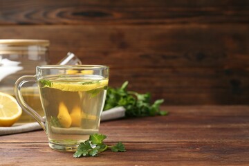 Healthy parsley tea with lemon slices on wooden table, space for text. Detox drink