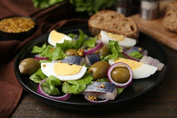 Delicious salad with herring, egg, mustard and vegetables on wooden table, closeup