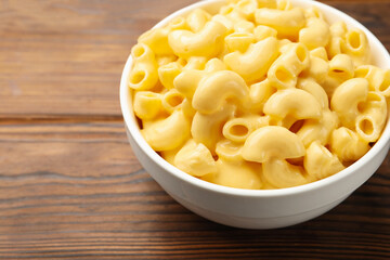 Delicious macaroni and cheese on wooden table, closeup