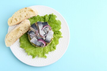 Delicious salad with herring, vegetables and bread on light blue background, top view. Space for text