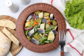 Delicious salad with herring and vegetables served on light grey table, flat lay