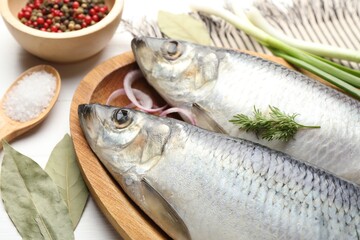 Salted herrings and spices on white table, closeup