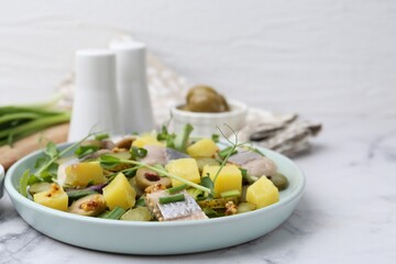 Delicious salad with herring and ingredients on white marble table, closeup