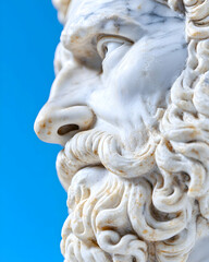 Profile of ancient marble bust against blue