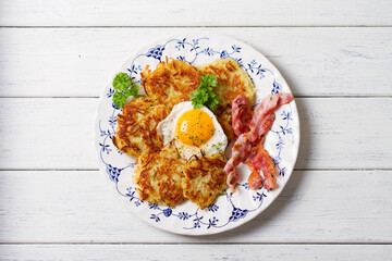 Potato Cakes. Vegetable fritters, latkes, hash browns. Vegetable pancakes with fried egg and bacon. High angle view