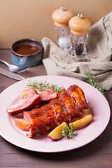 Barbecue grilled pork ribs with apples and rosemary on a plate