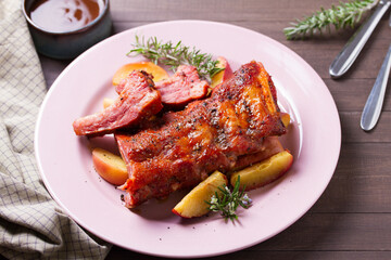 Barbecue grilled pork ribs with apples and rosemary on a plate