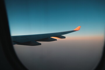 An Airplane Wing Silhouette Set Against a Beautifully Colorful Sky at Dusk During Sunset