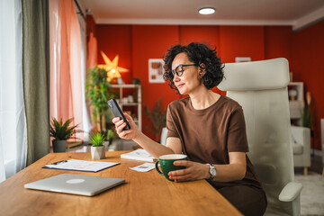 mature woman work from home and use mobile phone on coffee break