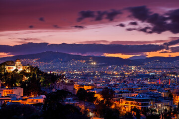 Fototapeta premium Breathtaking view of Athens at sunset, with illuminated buildings and a dramatic twilight sky. A stunning blend of history and modern city lights.