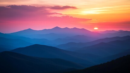 Fototapeta premium Vibrant sunset over layered mountain silhouettes.